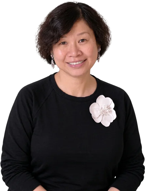 Jackie Wu: Business Growth, Sales Acceleration & Confidence Expert, in a studio portrait wearing a black top with a blush flower brooch