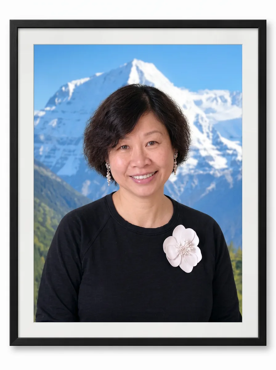 Jackie Wu in a matted and framed studio portrait with a mountain backdrop